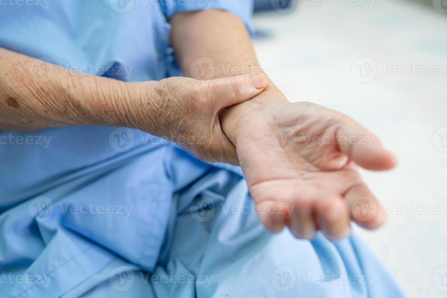 Aziatische senior of oudere oude dame vrouw patiënt voelt pijn haar hand op bed in verpleegafdeling, gezond sterk medisch concept. foto