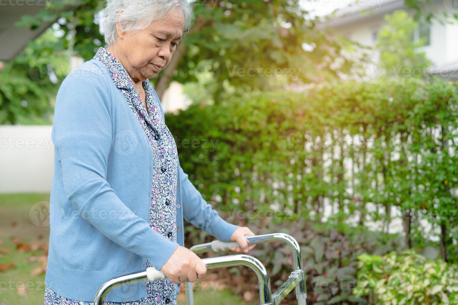 Aziatische senior of oudere oude dame vrouw gebruikt rollator met een sterke gezondheid tijdens het wandelen in het park in een fijne vakantie foto