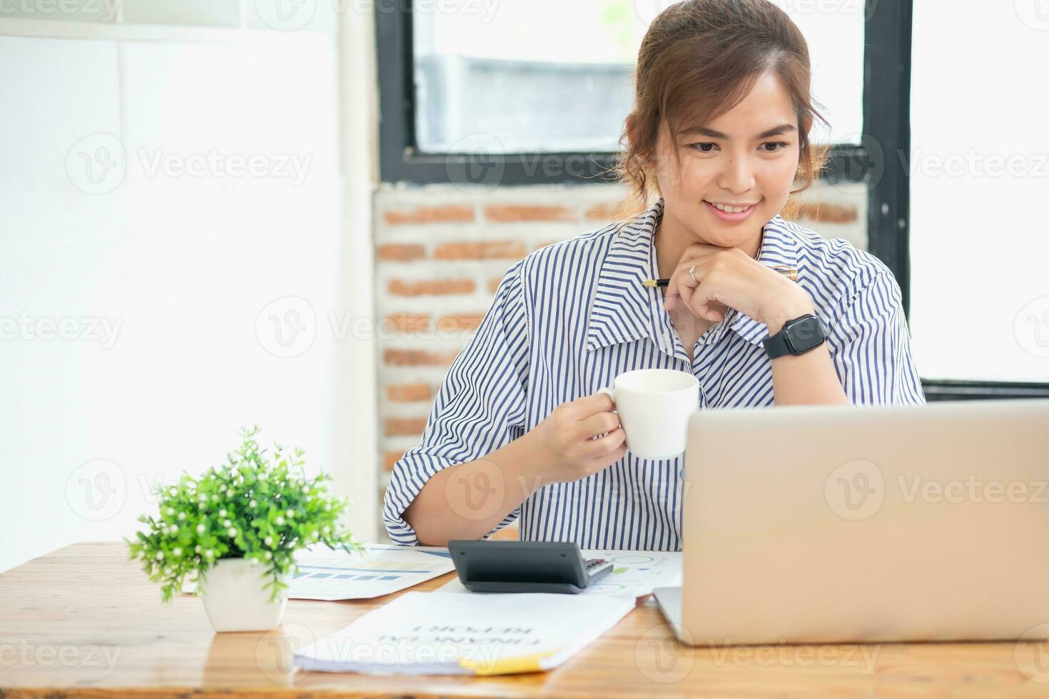Aziatisch zakenvrouw berekenen bedrijf verkoop met rekenmachine, laptop, en tablet Aan tafel interieur van zakenvrouw kantoor Bij de modern werkstation. foto