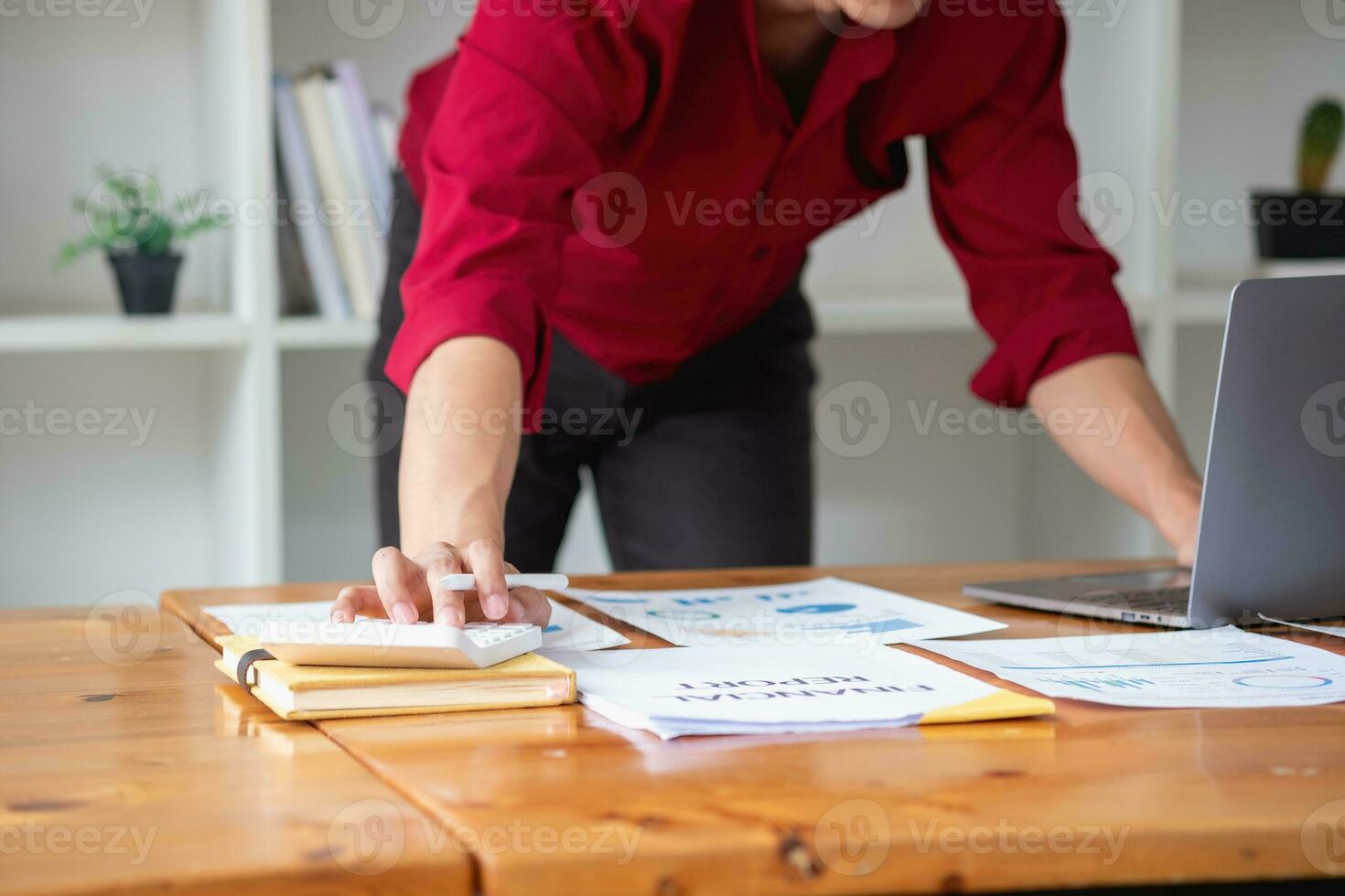 bedrijf accounting concept, een zakenman gebruik makend van een rekenmachine met een computer laptop, begroting, en lening papier in de kantoor. foto