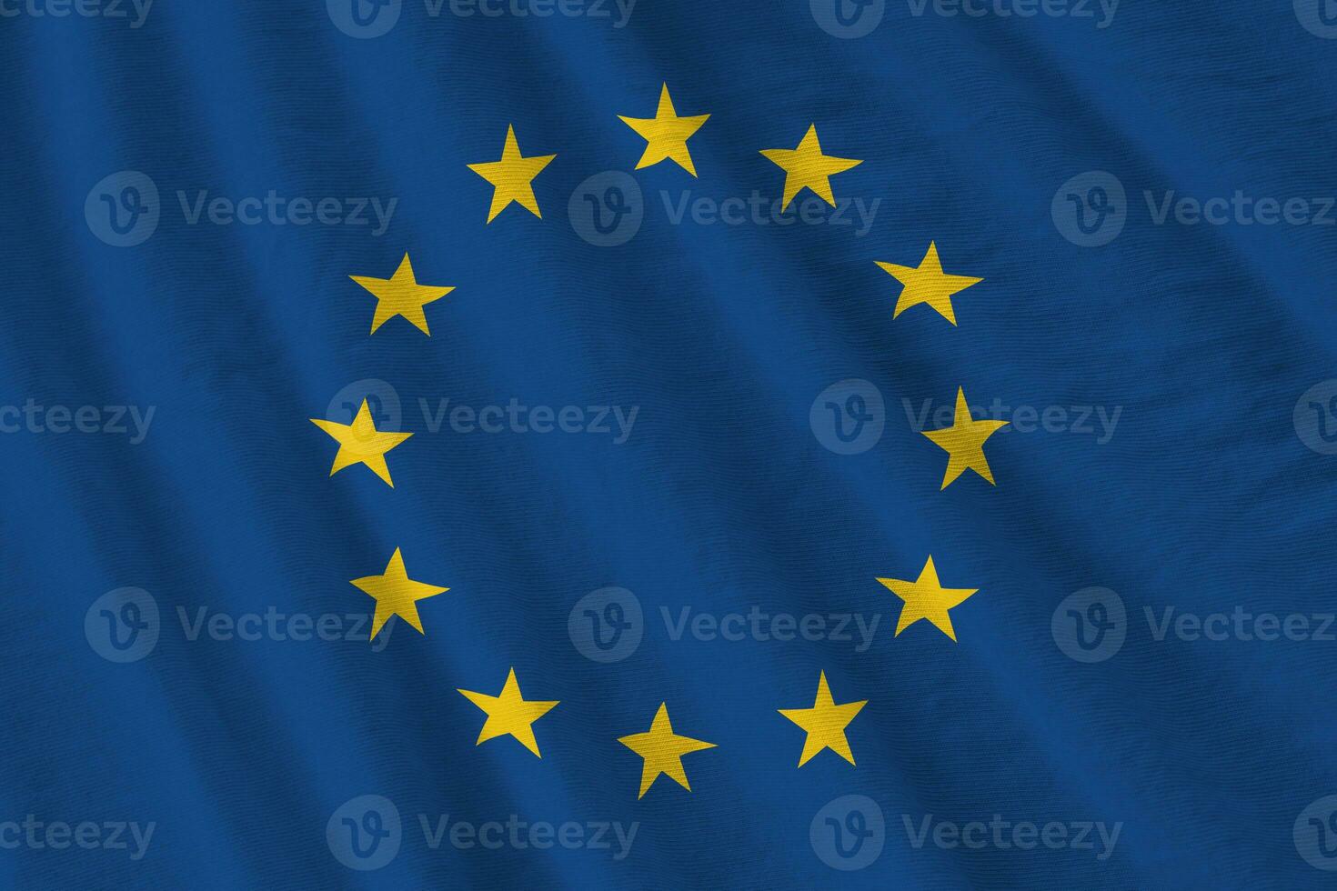 Europese unie vlag met groot vouwen golvend dichtbij omhoog onder de studio licht binnenshuis. de officieel symbolen en kleuren in banier foto