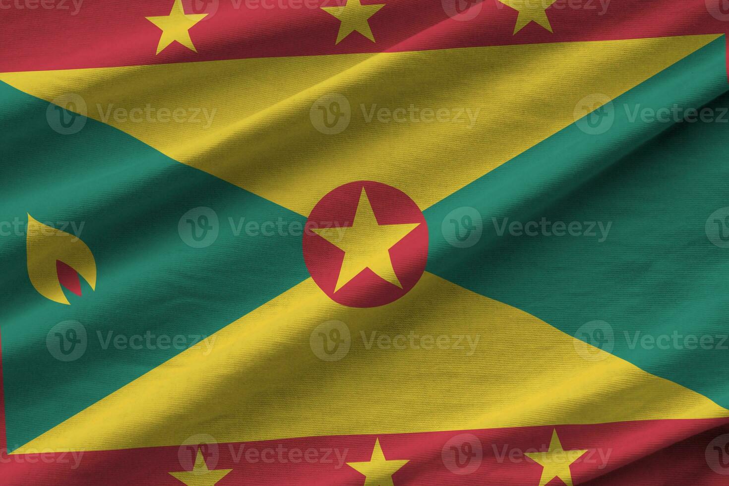 Grenada vlag met groot vouwen golvend dichtbij omhoog onder de studio licht binnenshuis. de officieel symbolen en kleuren in banier foto