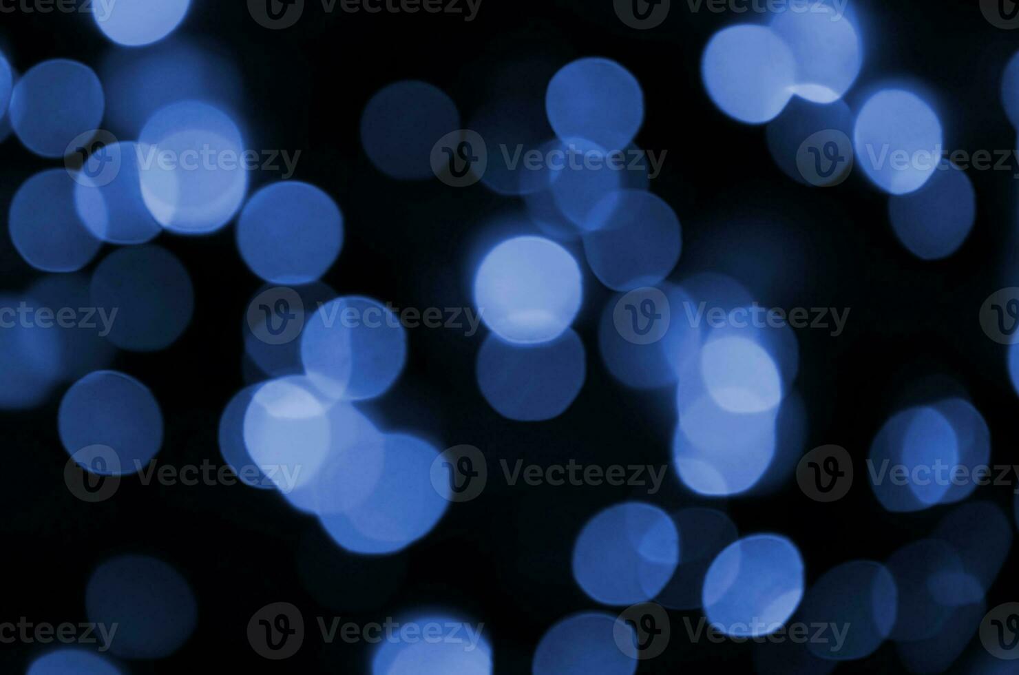 abstract achtergrond beeld met bokeh effect. veel helder gekleurde circulaire vormen Aan een donker achtergrond. fantoom klassiek blauw kleur foto