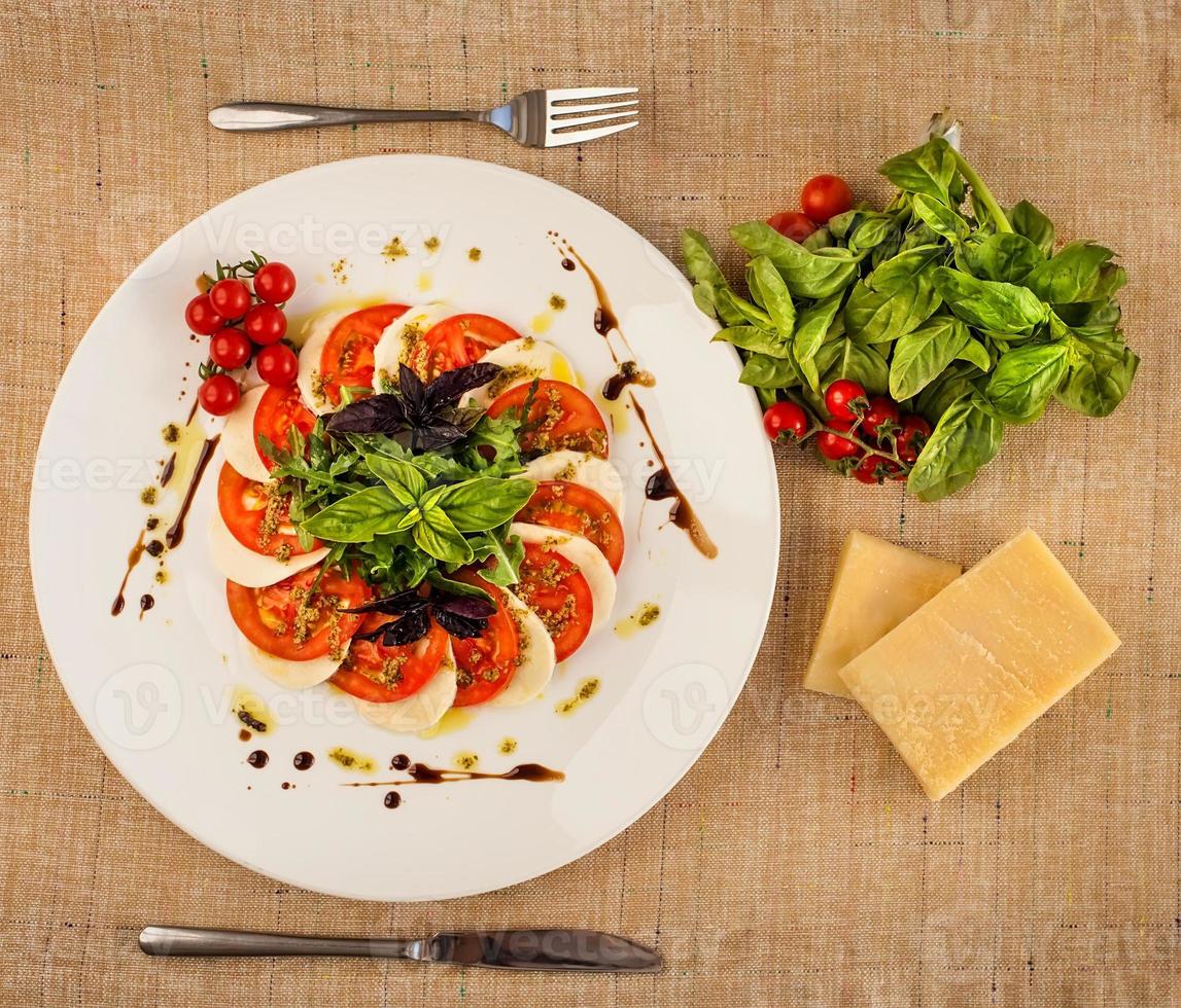 Italiaanse Caprese Salade Met Gesneden Tomaten, Mozzarella, Basilicum, Olijfolie foto