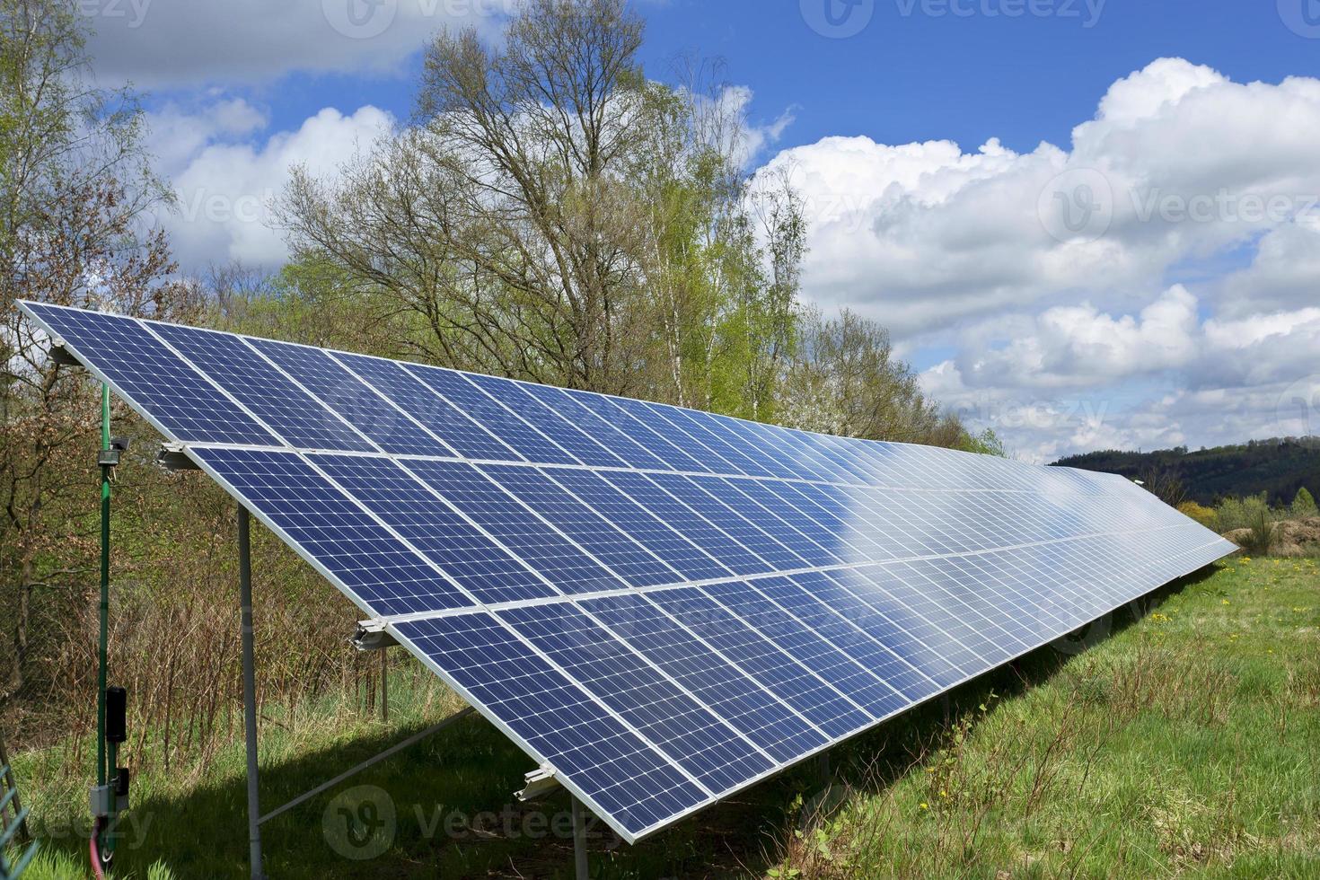 zonnecentrale op de voorjaarsbloeiende weide foto