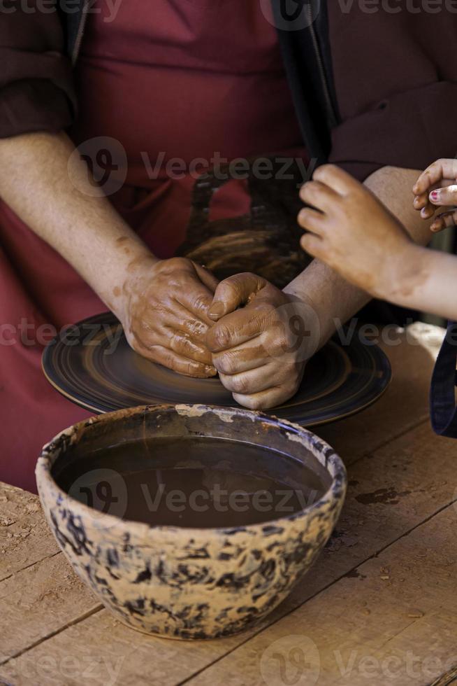 handen van een pottenbakker die klei vormt foto