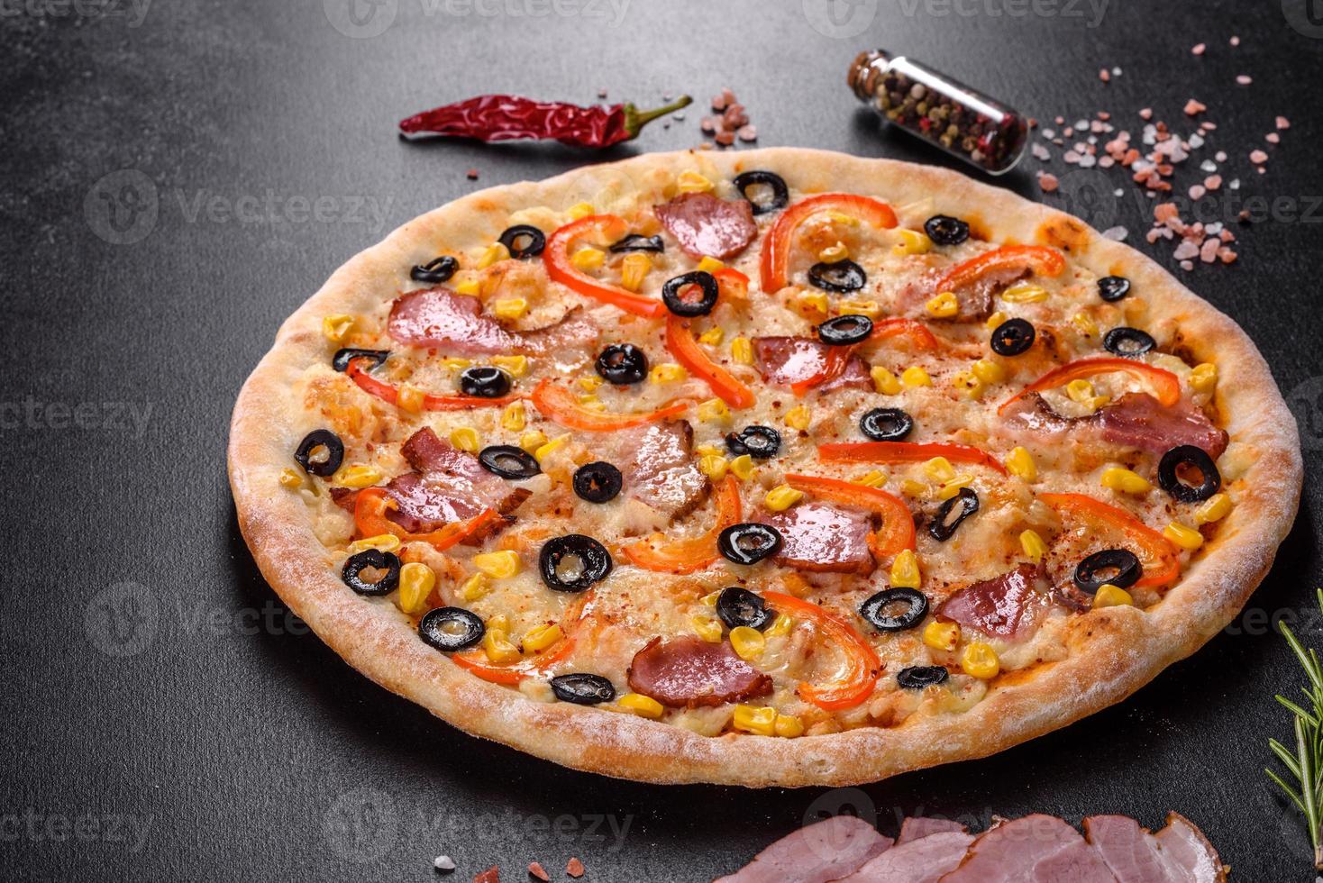 verse heerlijke pizza gemaakt in een haardoven met olijven, chilipeper en ham foto
