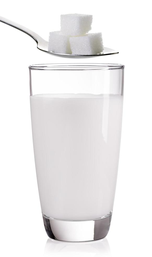 glas melk met suiker op een witte achtergrond foto