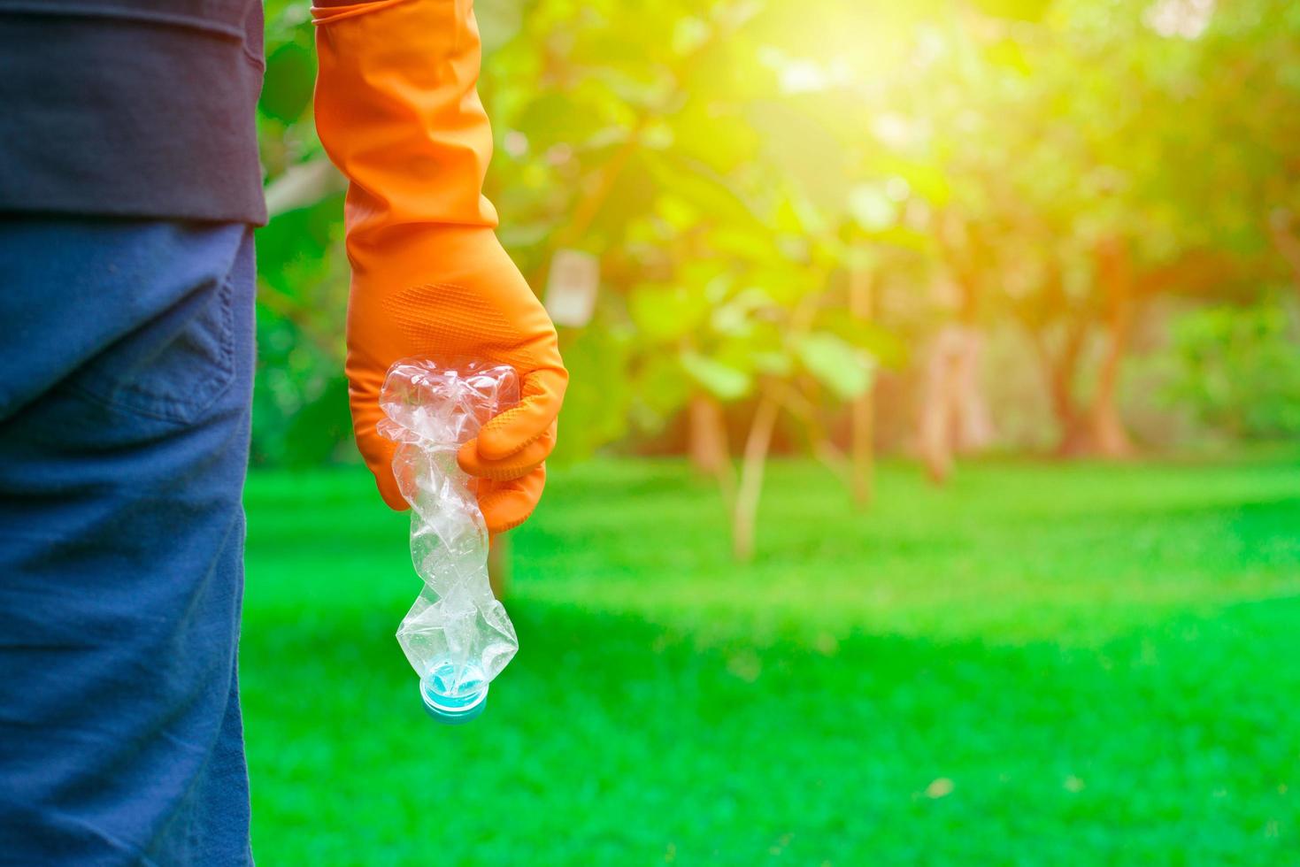 vrijwilliger man's hand oppakken van plastic fles foto