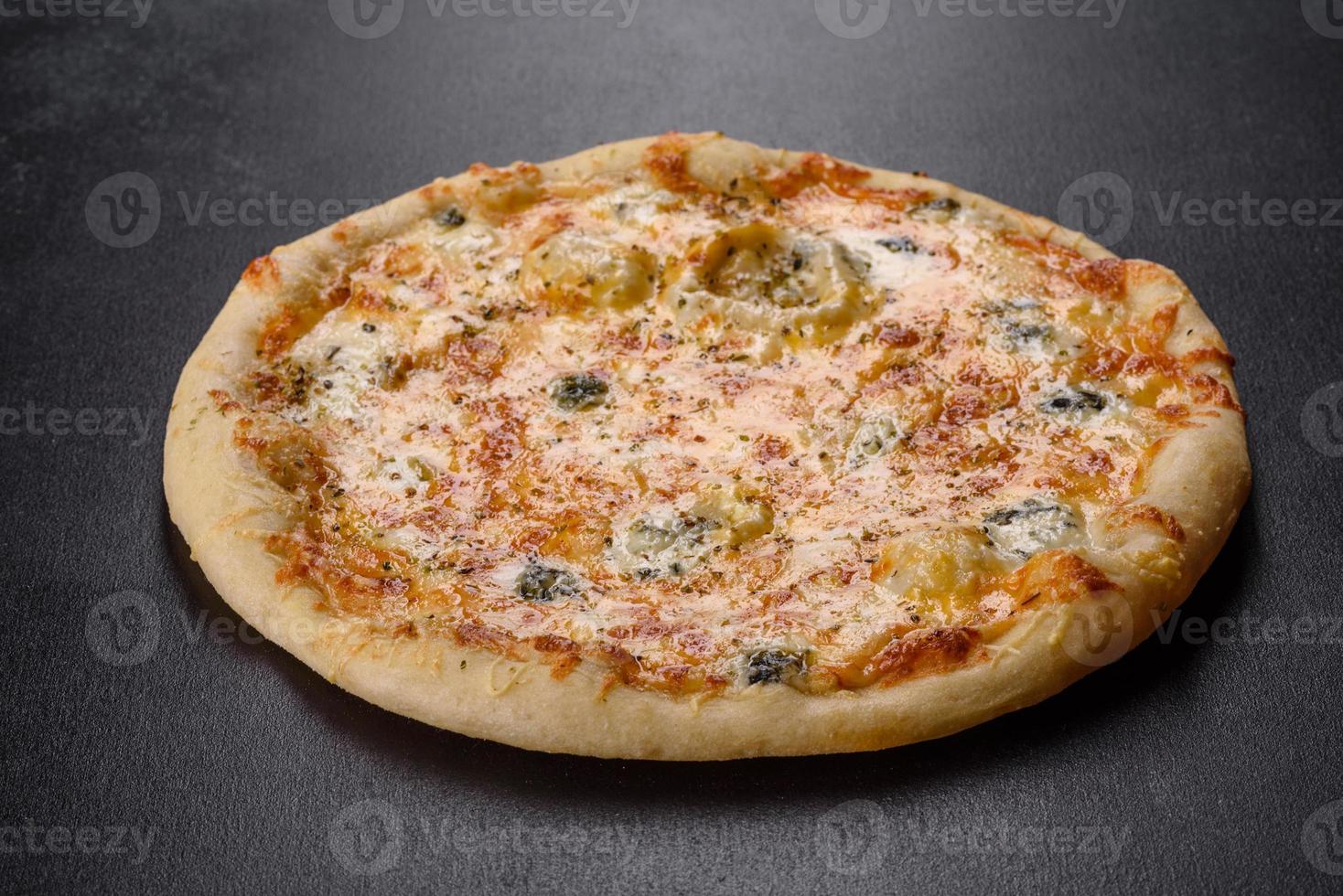 smakelijke verse ovenpizza met tomaten, kaas en champignons op een donkere betonnen ondergrond foto