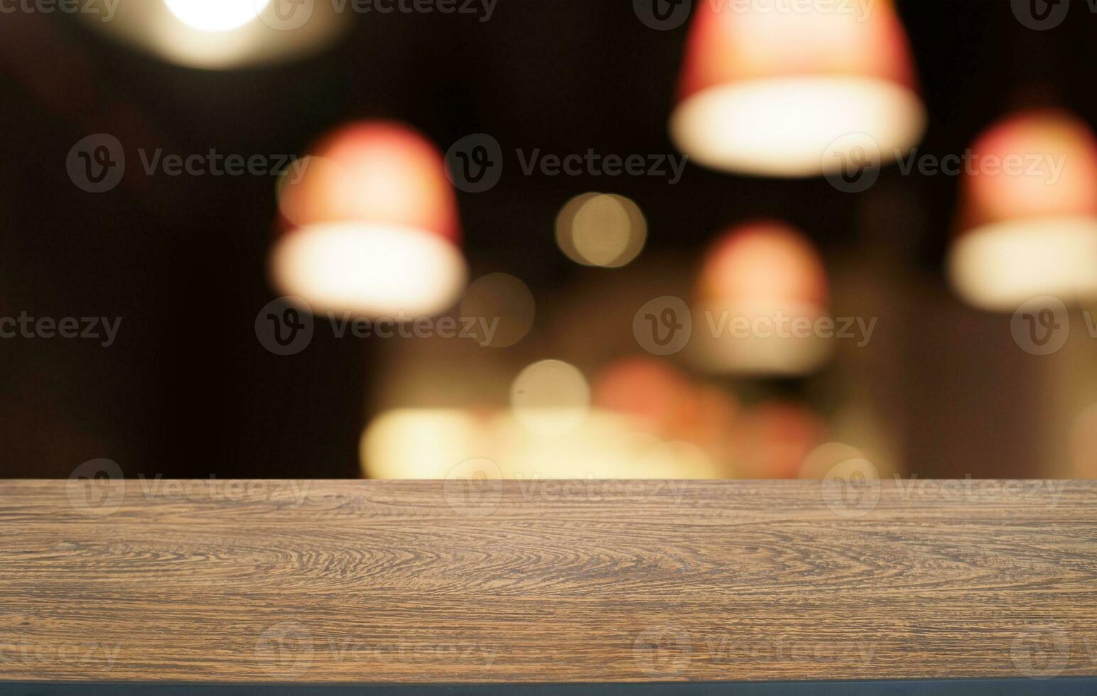 bespotten omhoog voor ruimte. leeg donker houten tafel in voorkant van abstract wazig bokeh achtergrond van restaurant . kan worden gebruikt voor Scherm of montage uw Product foto