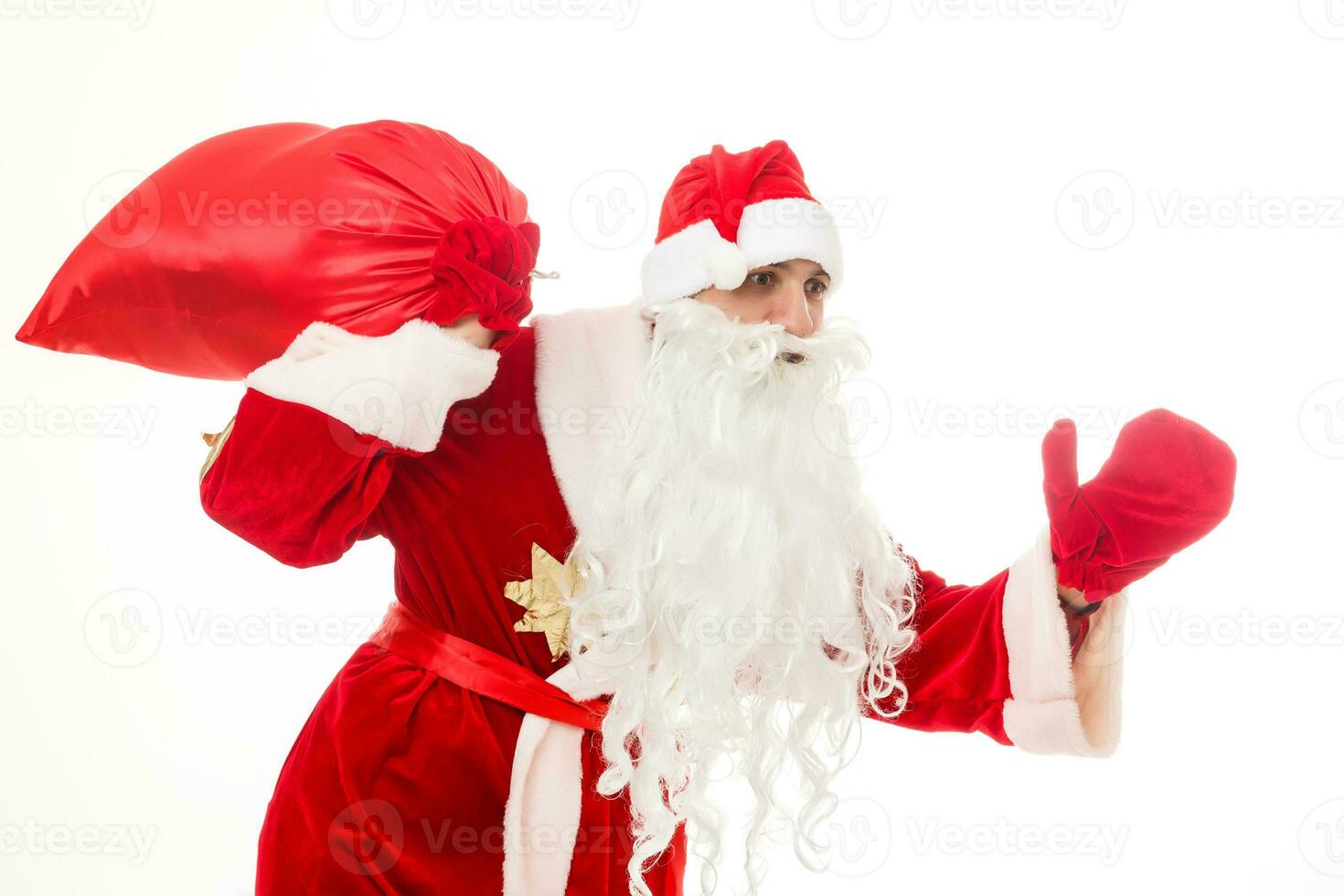 de kerstman claus staand omhoog Aan wit achtergrond met zijn zak vol van cadeaus foto