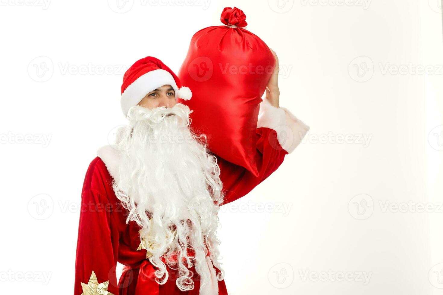 de kerstman claus staand omhoog Aan wit achtergrond met zijn zak vol van cadeaus foto