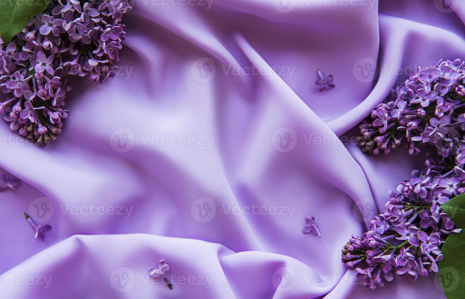 lila bloemen op een achtergrond van lila satijn foto