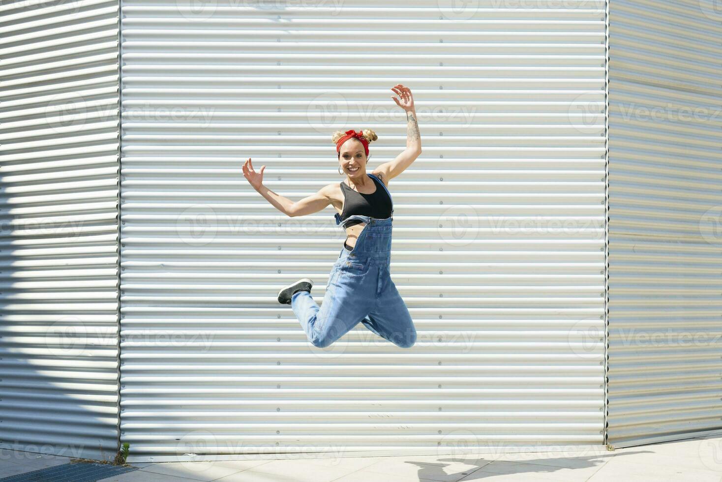 glimlachen jong vrouw jumping in de lucht foto