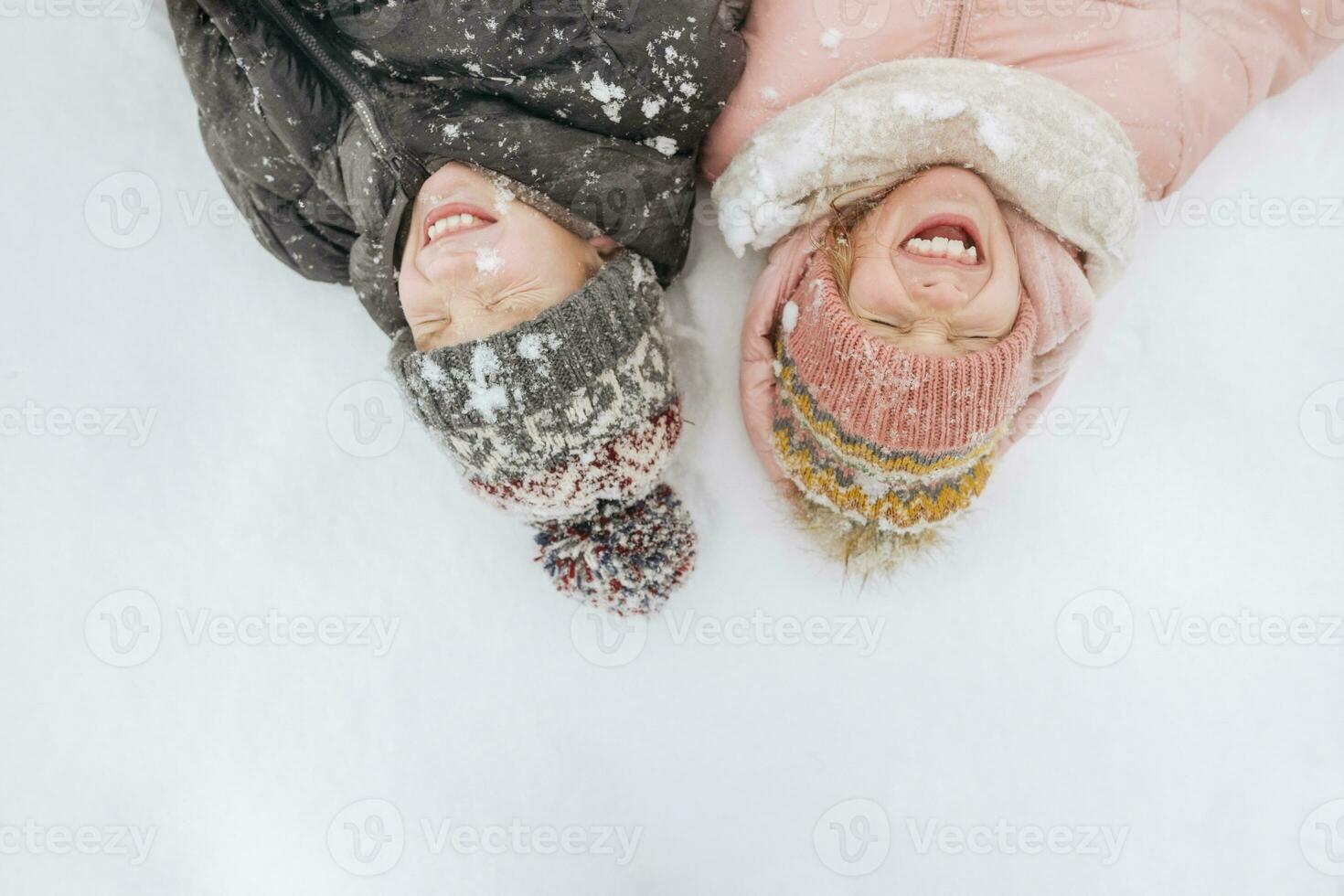portret van twee broers en zussen aan het liegen Aan sneeuw foto