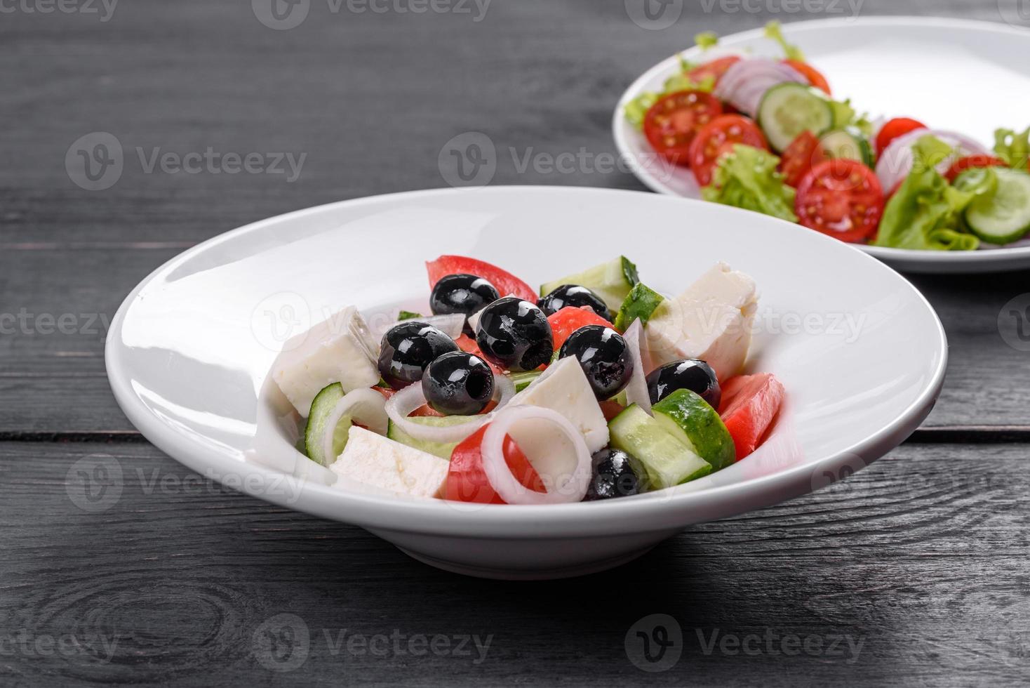 verse heerlijke Griekse salade met tomaat, komkommer, uien en olijven met olijfolie foto