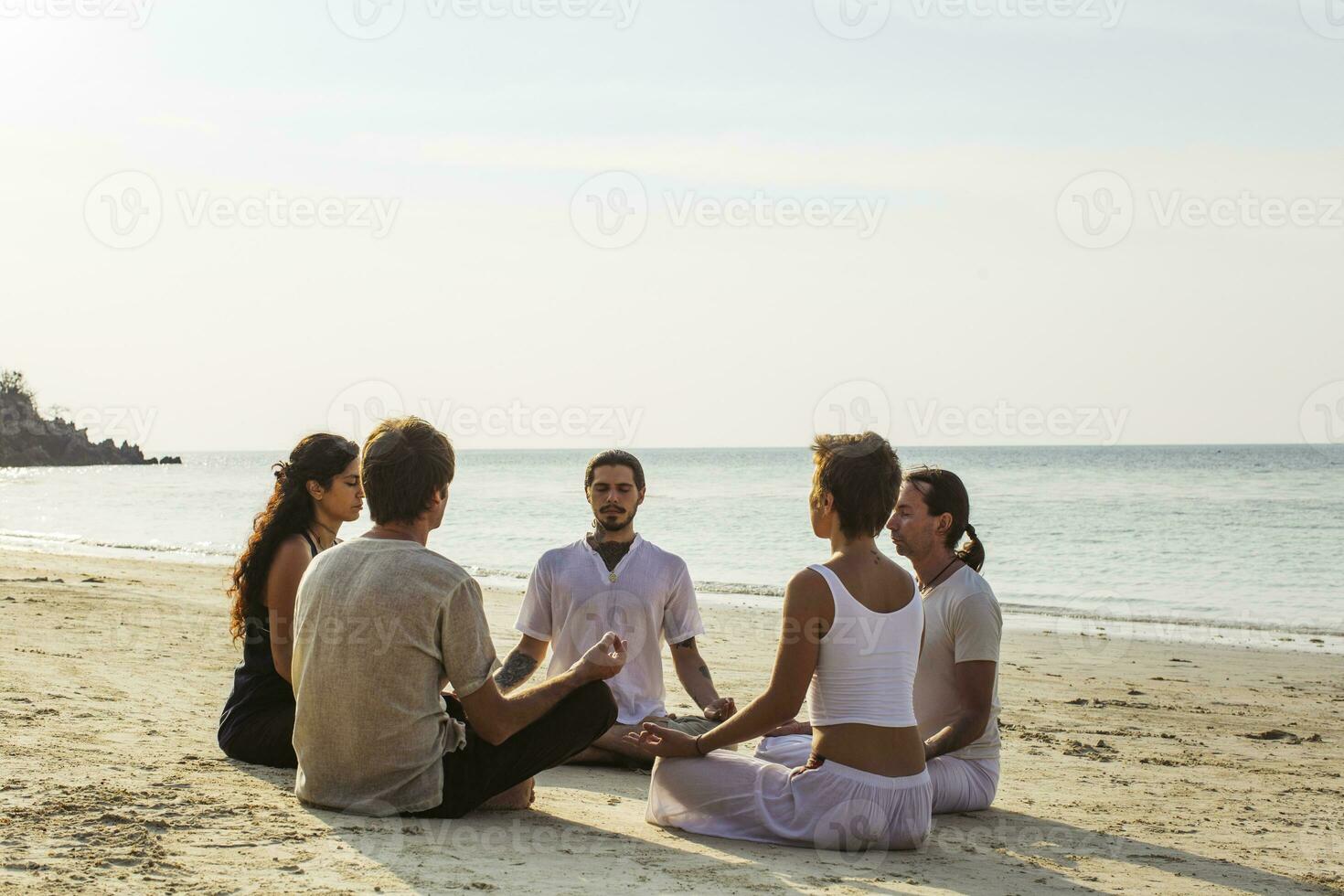 Thailand, koh Phangan, groep van mensen mediteren samen Aan een strand foto
