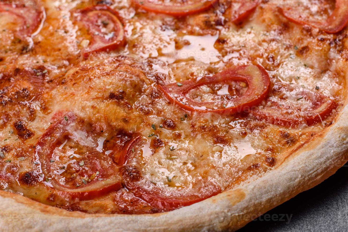 verse heerlijke Italiaanse pizza met champignons en tomaten op een donkere betonnen ondergrond concrete foto