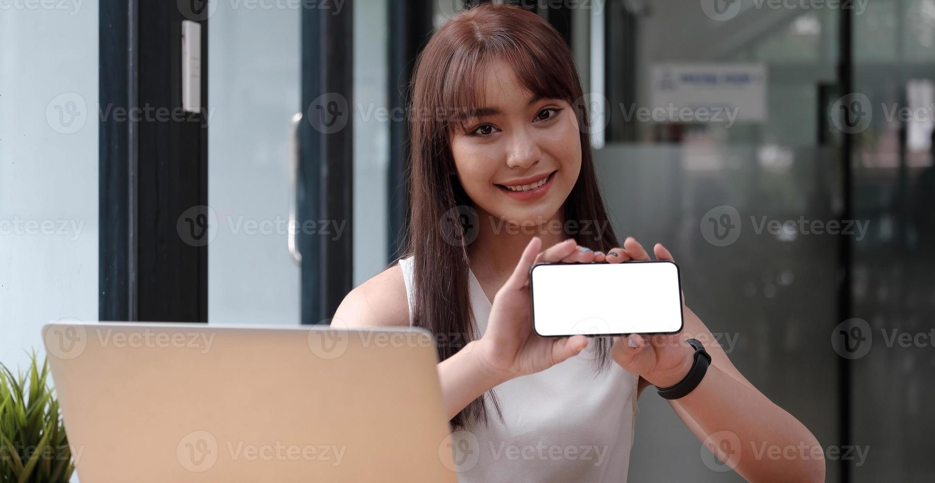 glimlachende gelukkige vrouw die lege smartphone toont foto