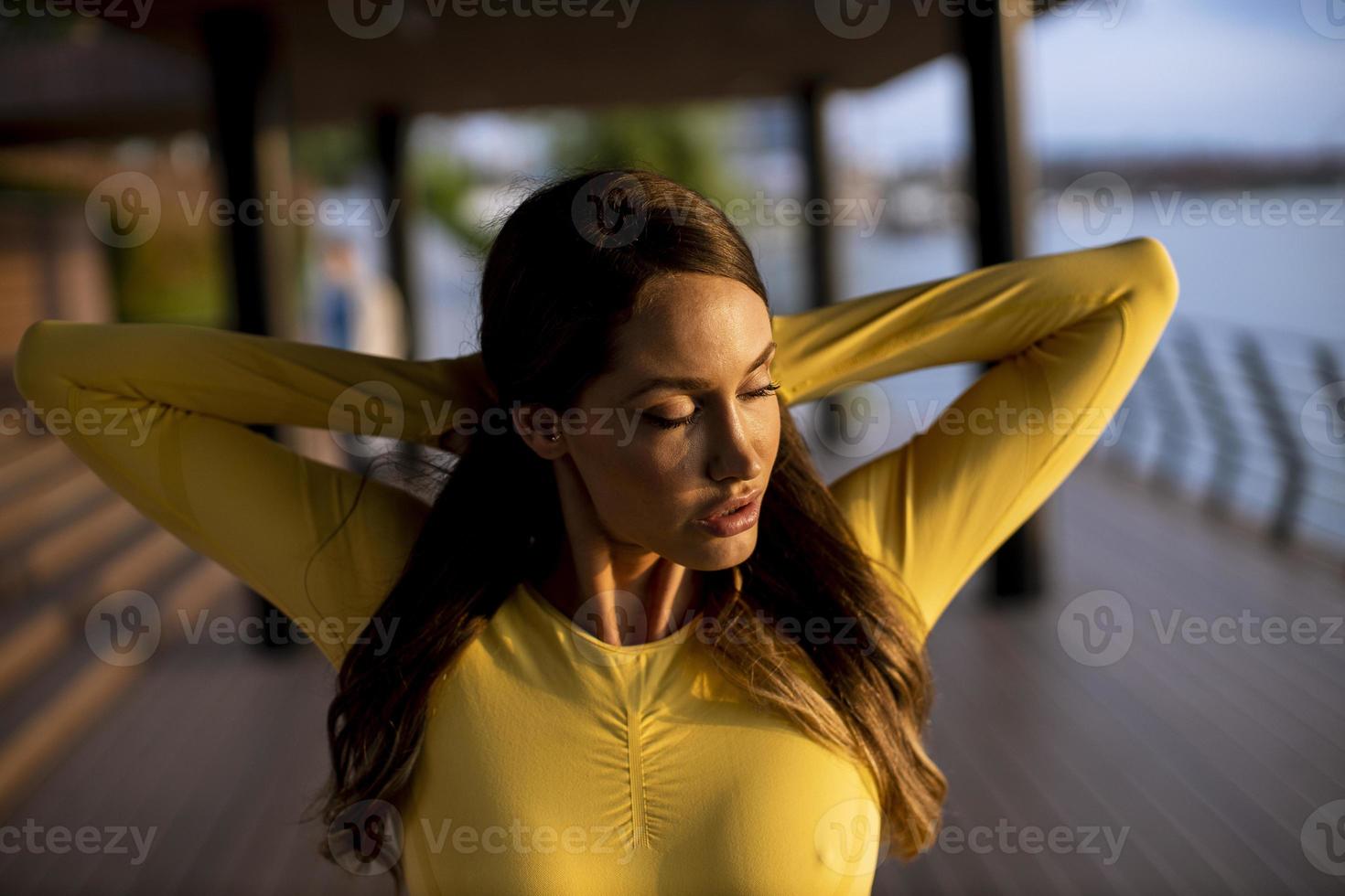 jonge vrouw die zich uitstrekt aan de rivier foto