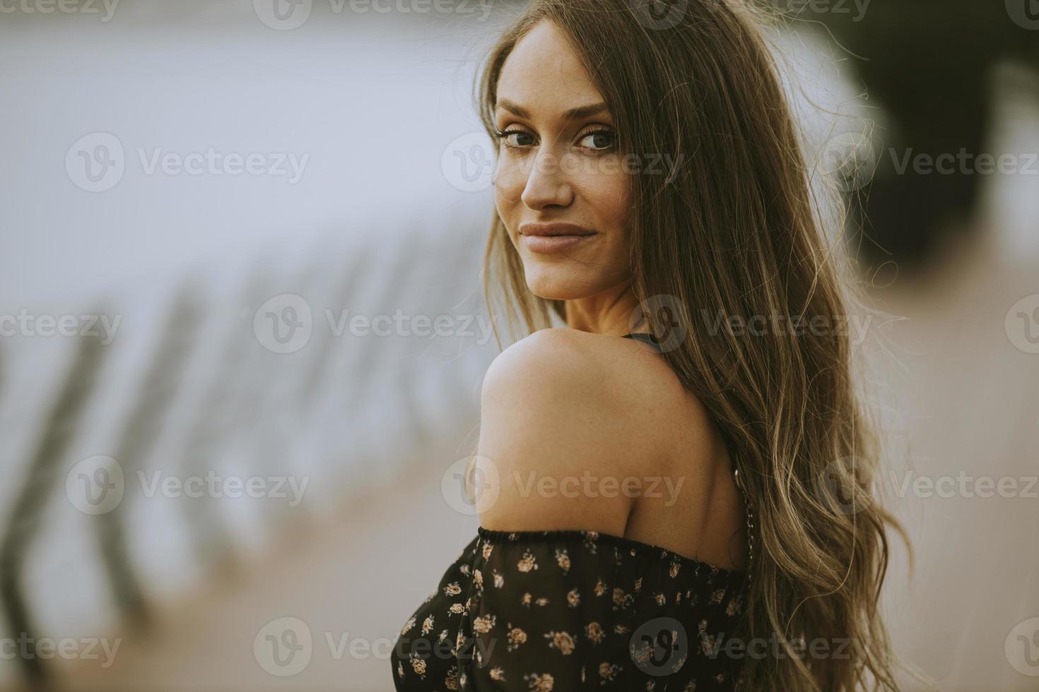 jonge langharige brunette vrouw die op de rivier loopt foto