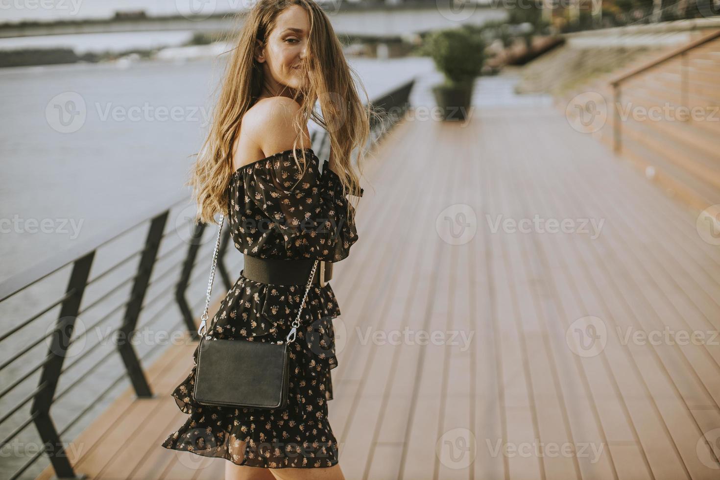 jonge langharige brunette vrouw die op de rivier loopt foto
