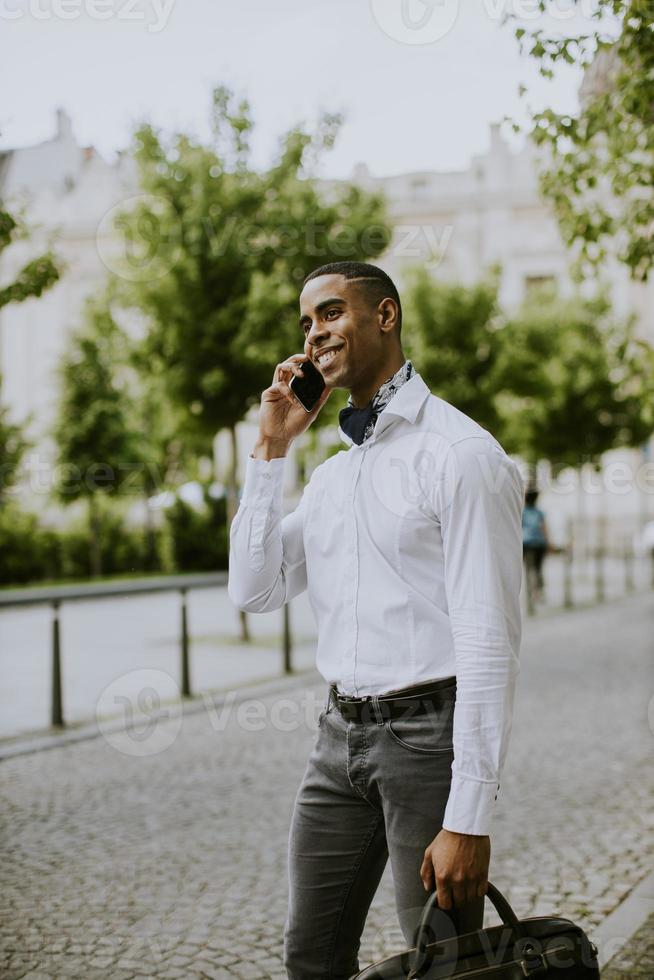 jonge Afro-Amerikaanse zakenman met behulp van een mobiele telefoon foto