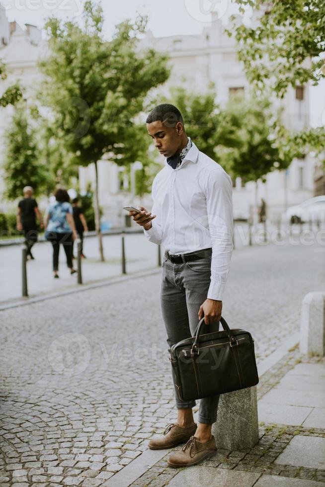 jonge Afro-Amerikaanse zakenman met behulp van een mobiele telefoon foto