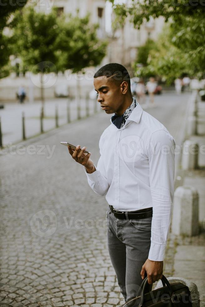jonge Afro-Amerikaanse zakenman met behulp van een mobiele telefoon foto