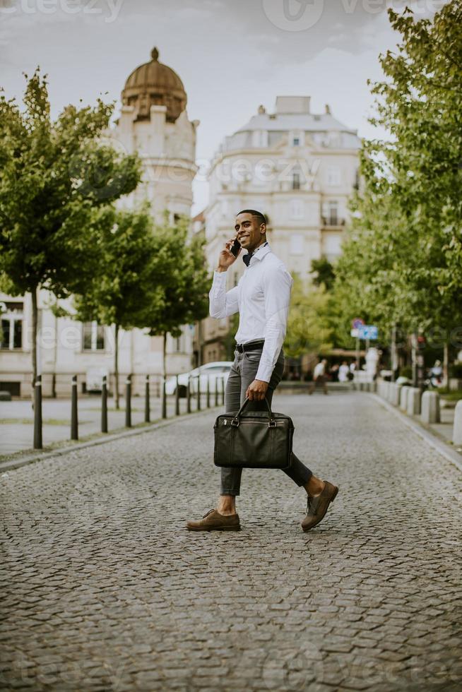 jonge Afro-Amerikaanse zakenman met behulp van een mobiele telefoon foto