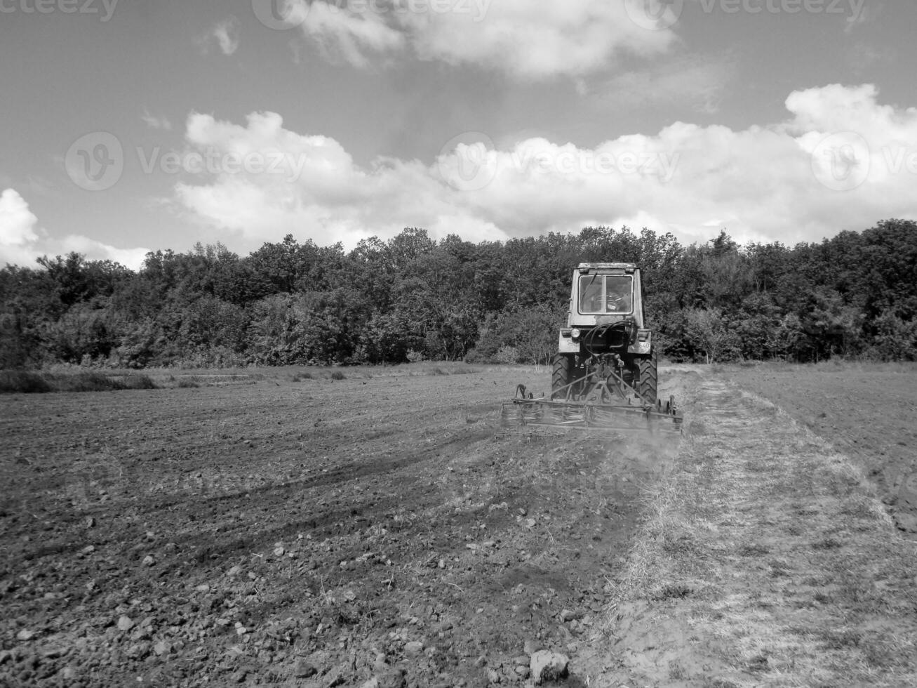 geploegd veld- door trekker in zwart bodem Aan Open platteland natuur foto