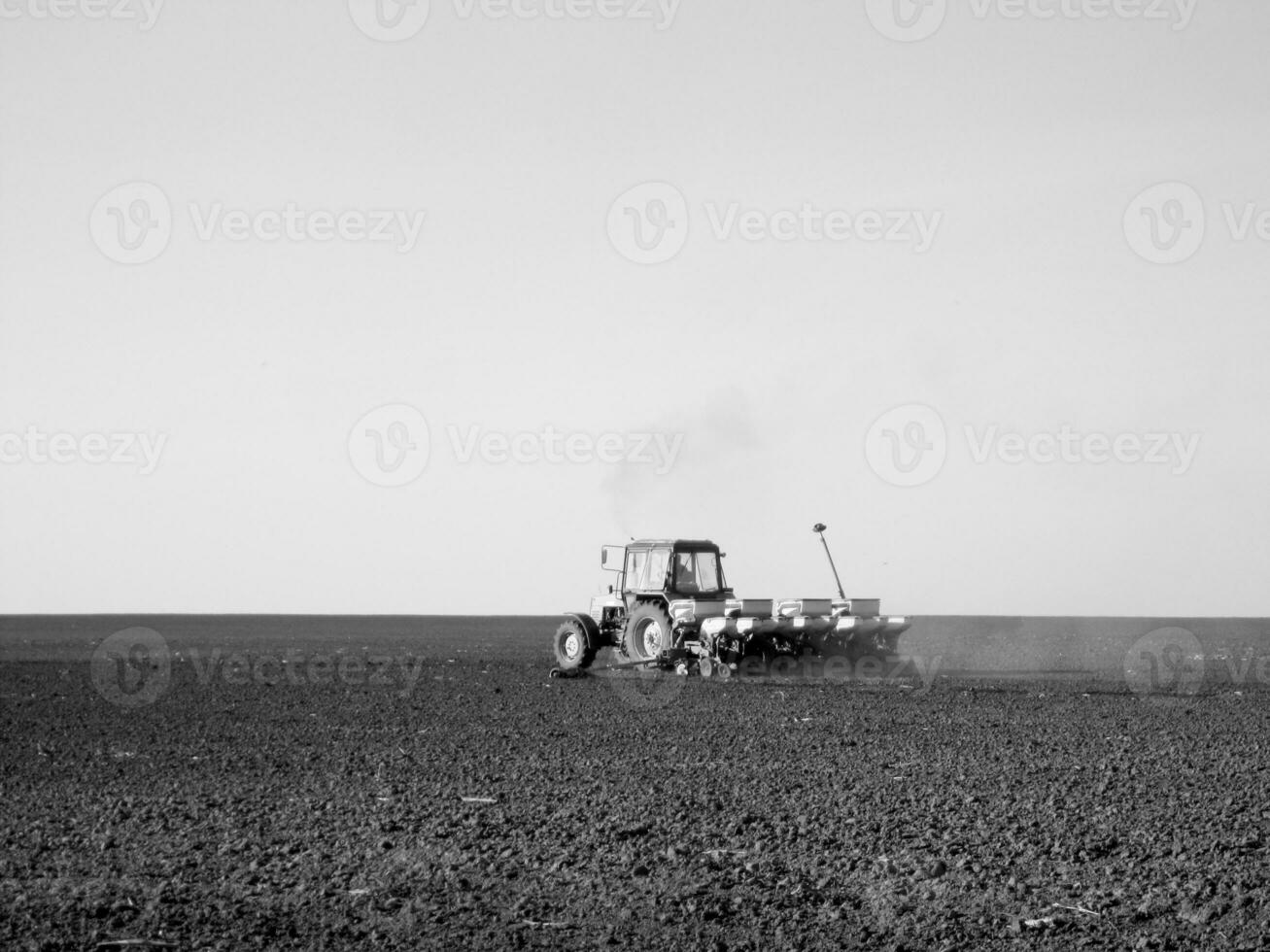 geploegd veld- door trekker in zwart bodem Aan Open platteland natuur foto