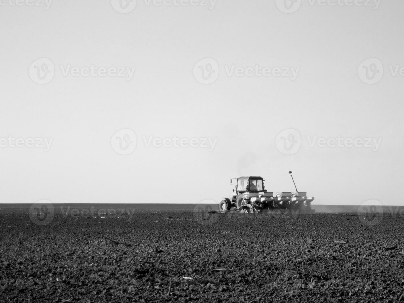 geploegd veld- door trekker in zwart bodem Aan Open platteland natuur foto