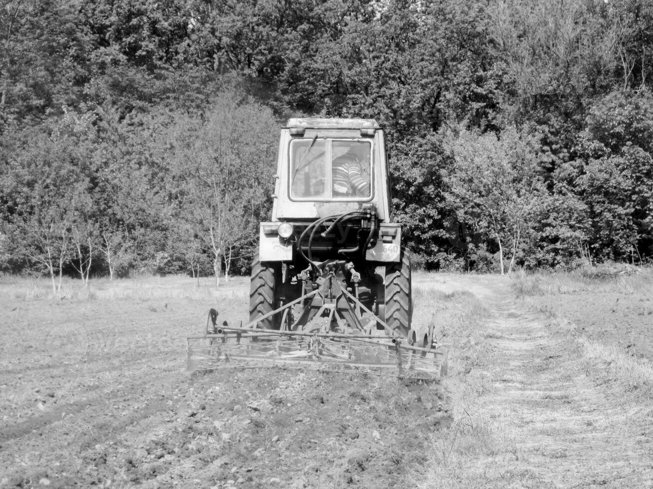 geploegd veld- door trekker in zwart bodem Aan Open platteland natuur foto