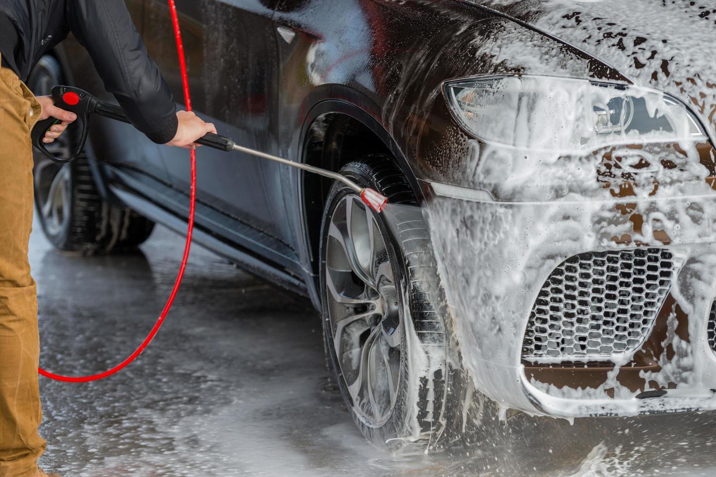 auto zonder aanraking wassen self-service. wassen met water en schuim. foto