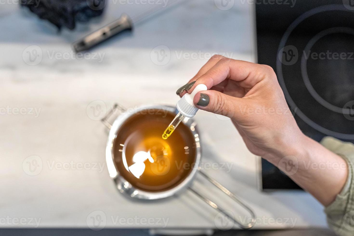 bovenaanzicht van warme cacaoboter gesmolten in een waterbad voor het maken van cosmetica voor lichaamsverzorging. het kookproces, de toevoeging van aromatische oliën. thuis kuuroord. kleine onderneming foto