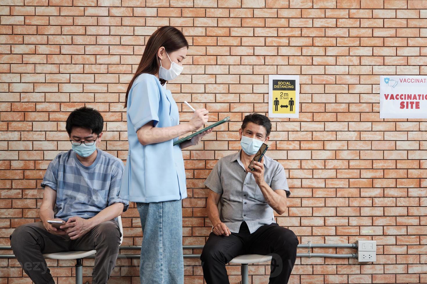 verpleegster controleert wachtrij voor vaccinatie tegen coronavirus. foto