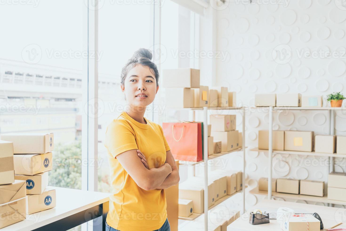 Aziatische vrouw bedrijfseigenaar die thuis werkt met verpakkingsdoos op de werkplek - online winkelen mkb-ondernemer of freelance werkconcept foto