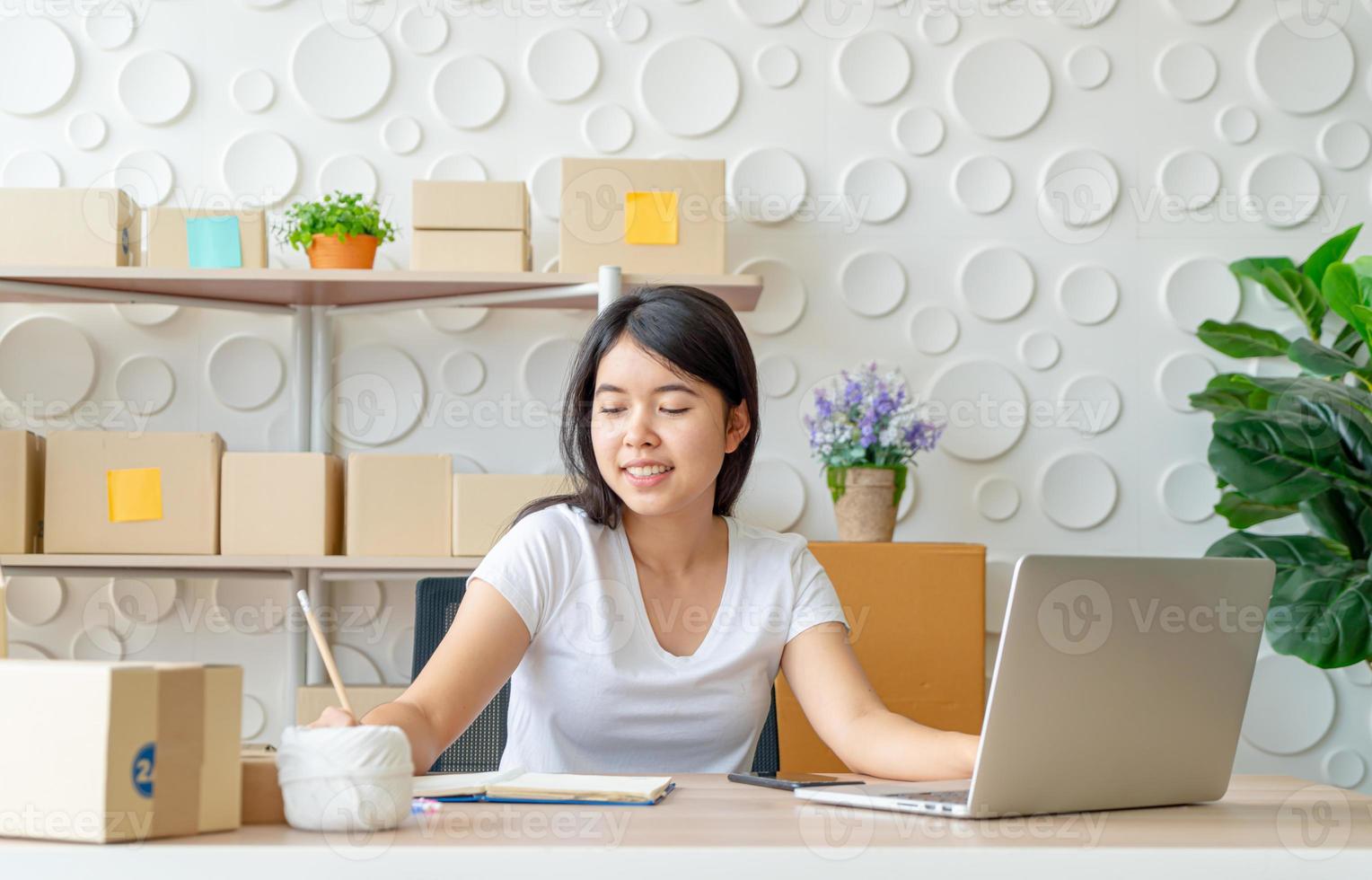 jonge Aziatische vrouw startende kleine ondernemer die met digitale tablet op de werkplek werkt - online verkoop, e-commerce, verzendconcept foto