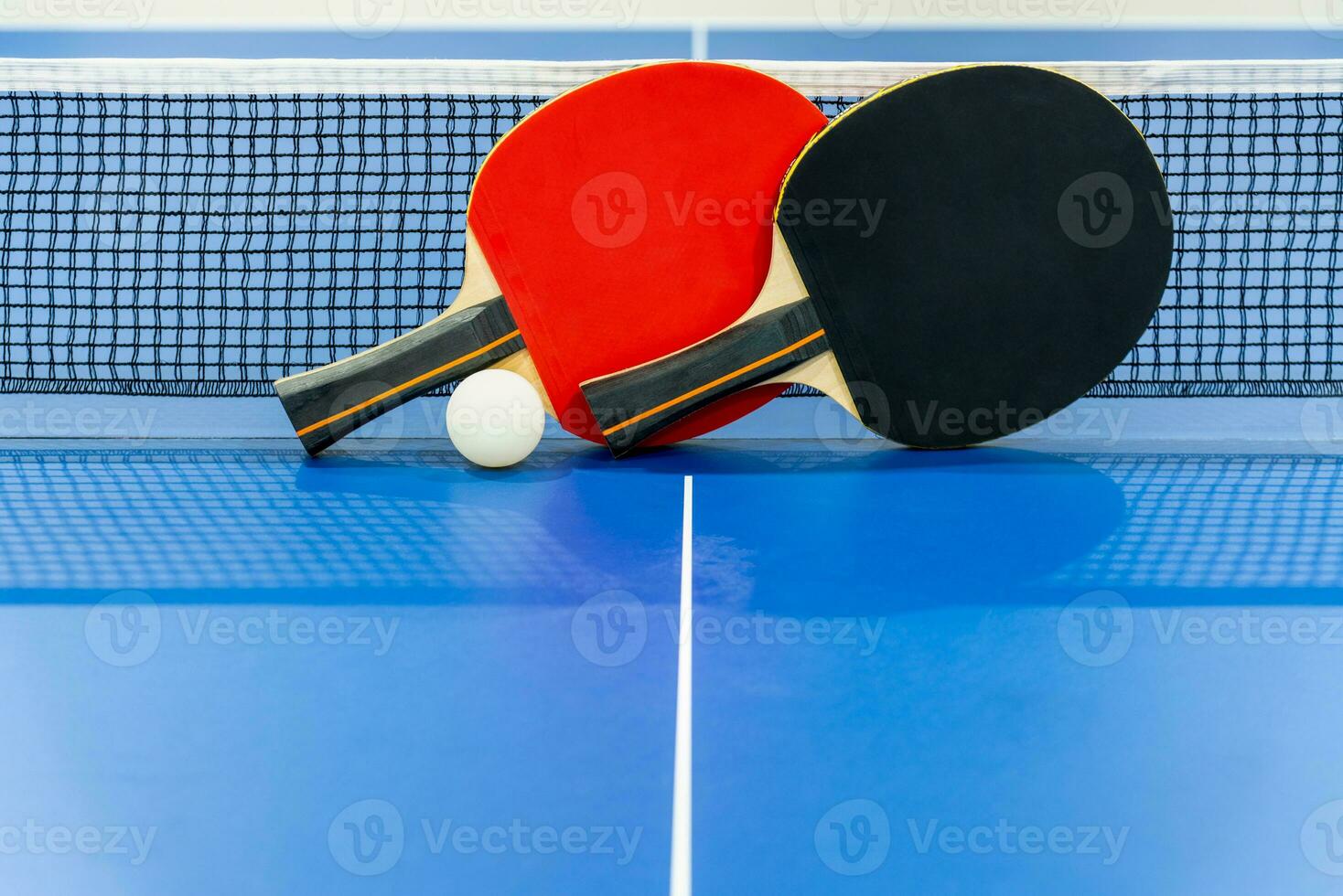 zwart en rood tafel tennis peddelen met een netto foto