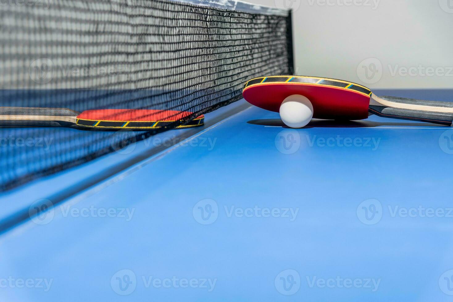 rood tafel tennis peddelen wit bal en een netto foto