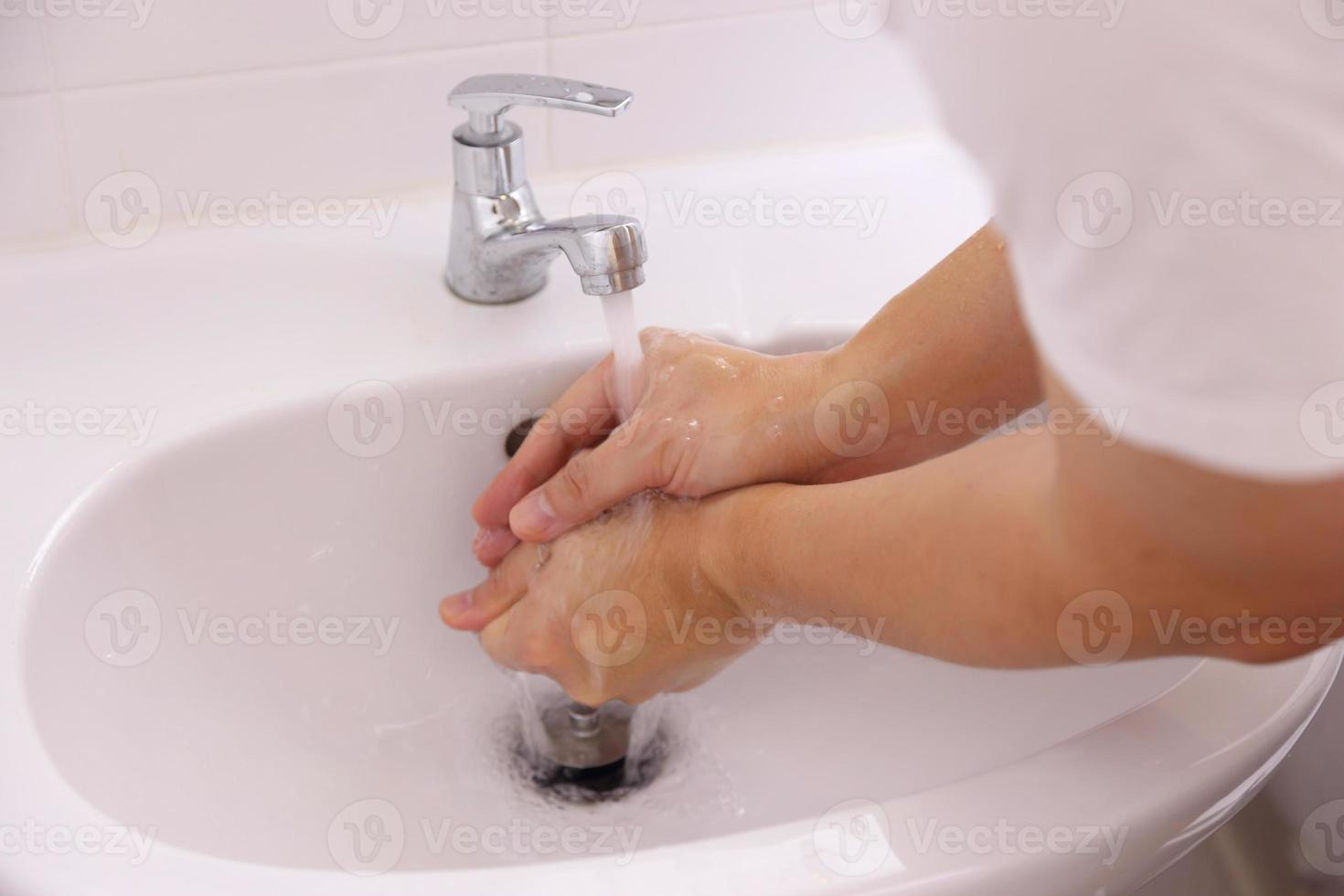 handen wassen in wastafel foto