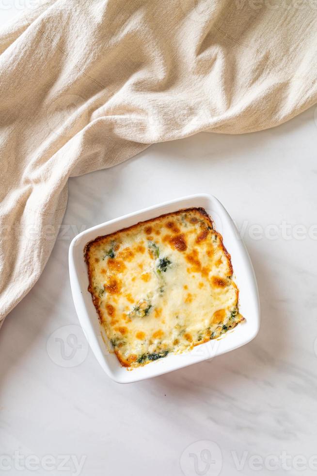 gebakken spinazie lasagne met kaas in witte plaat foto