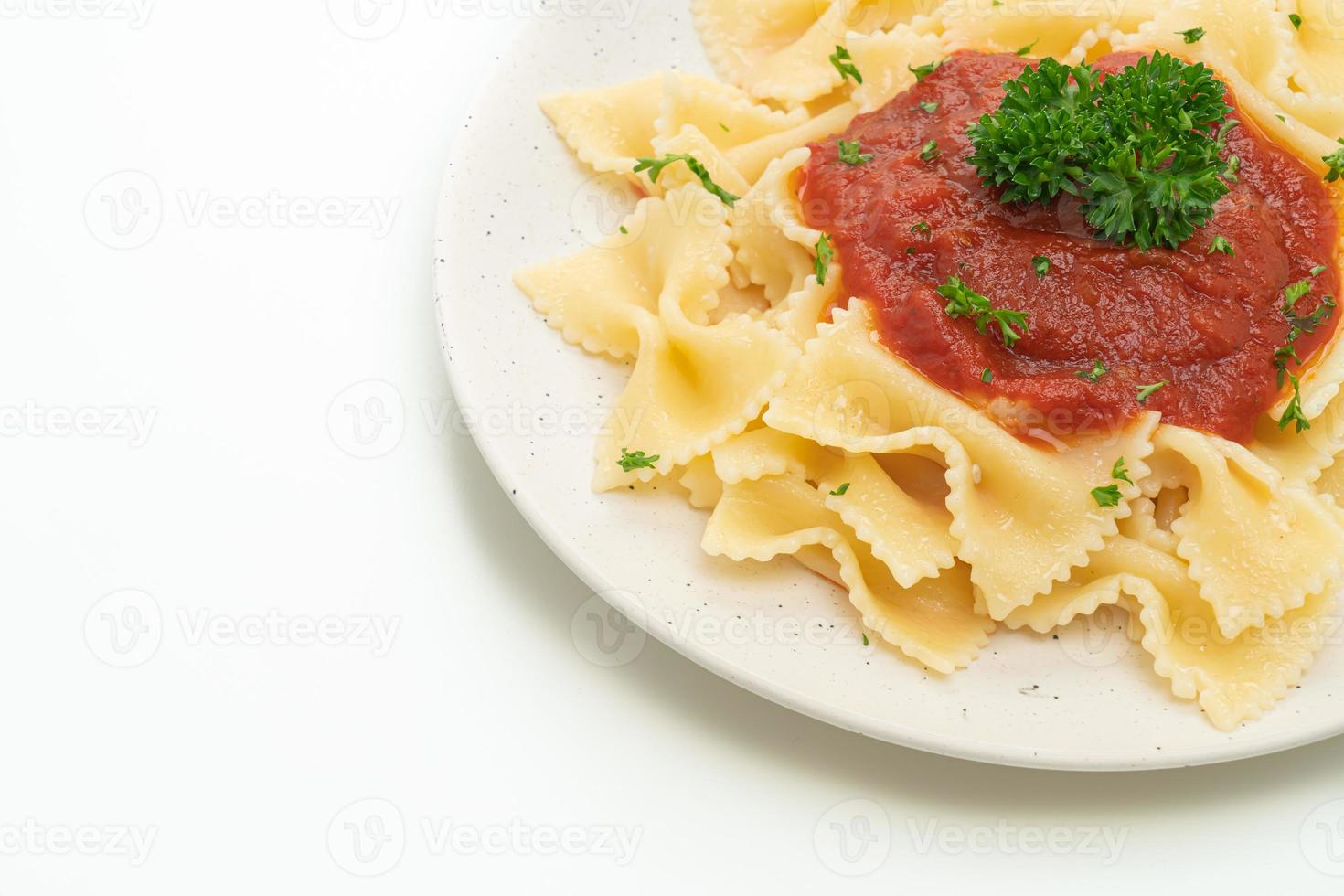 farfalle pasta in tomatensaus met peterselie - italiaans eten foto