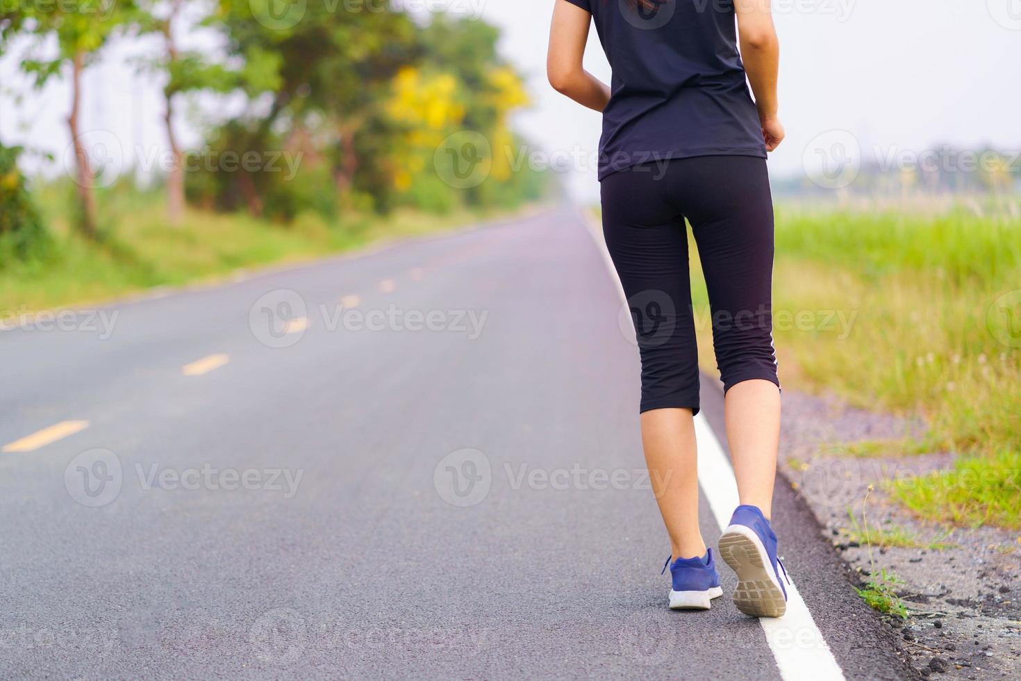 vrouw voeten lopen op de weg, gezonde fitness vrouw training foto