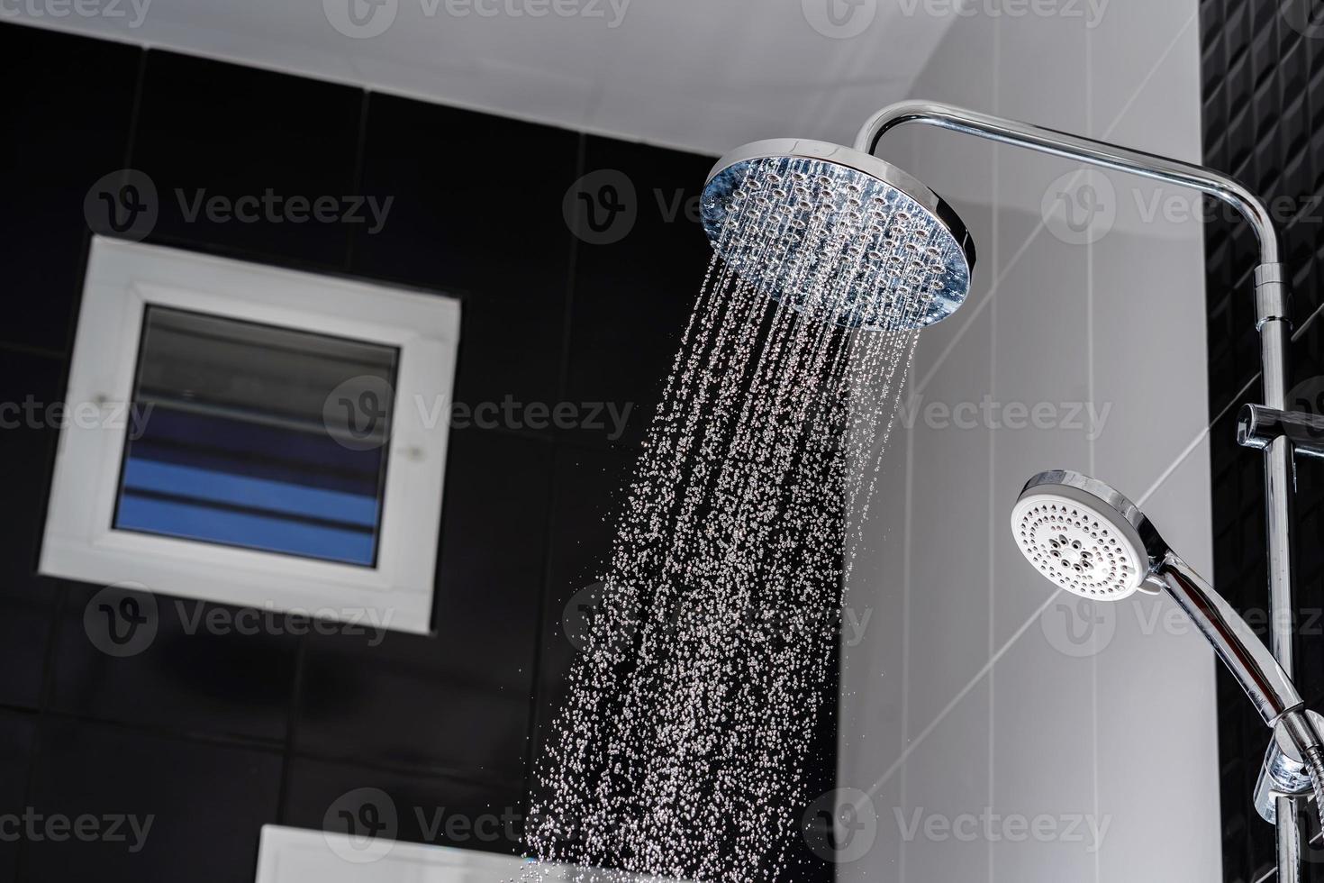 close-up van water dat uit de douche in de badkamer stroomt foto