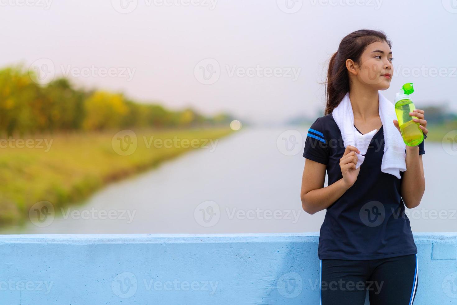 portret van een mooi meisje in sportkleding met een fles water foto