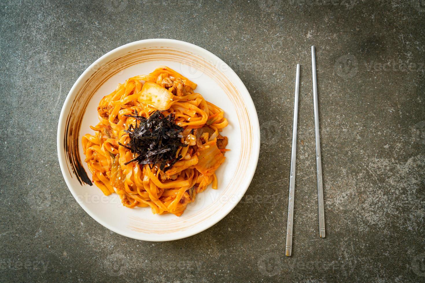 roergebakken udon noedels met kimchi en varkensvlees - koreaanse voedselstijl foto