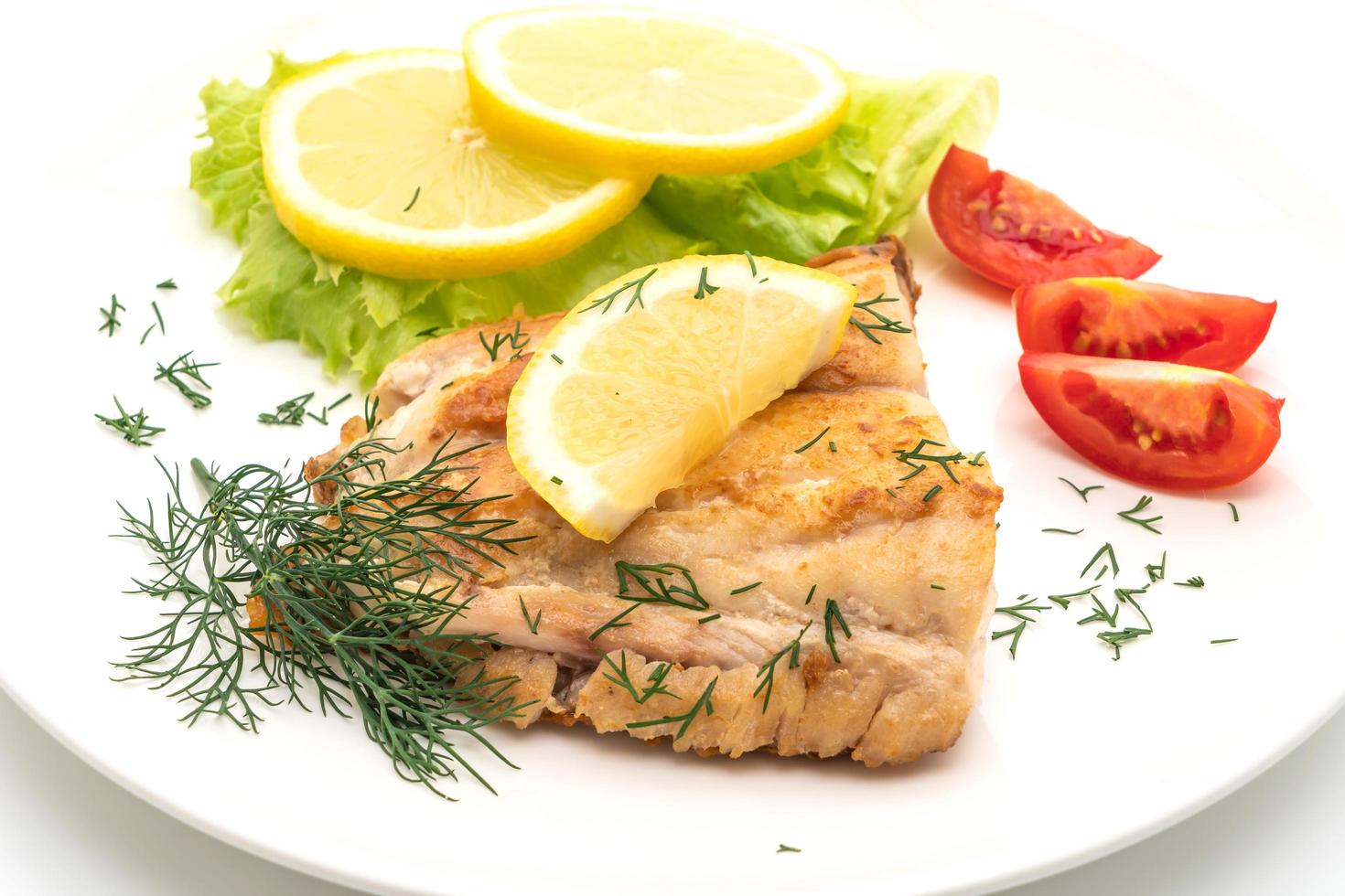 Gegrilde snapper vis steak met groenten geïsoleerd op een witte achtergrond foto